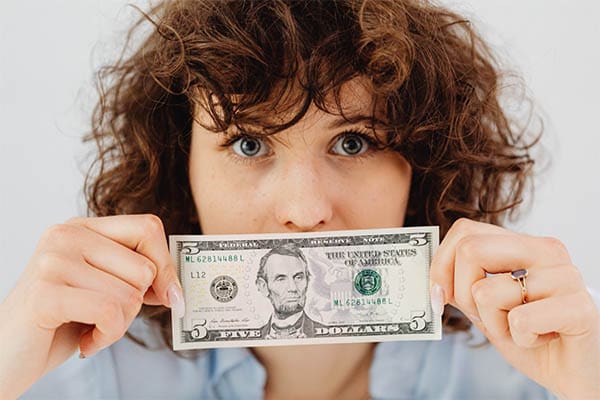 woman holding a five dollar bill