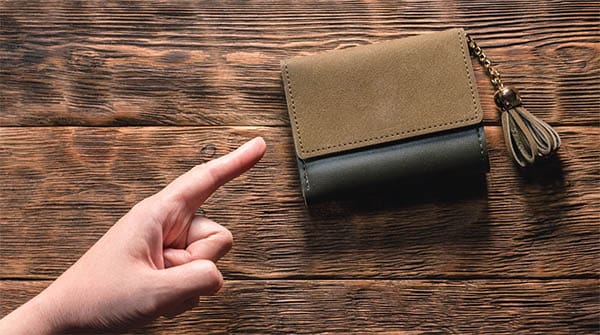finger pointing at a wallet