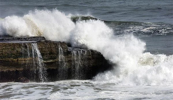 big waves crashing on a rocky coastline