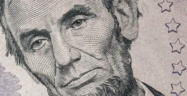 close up of lincoln's face on the five dollar bill