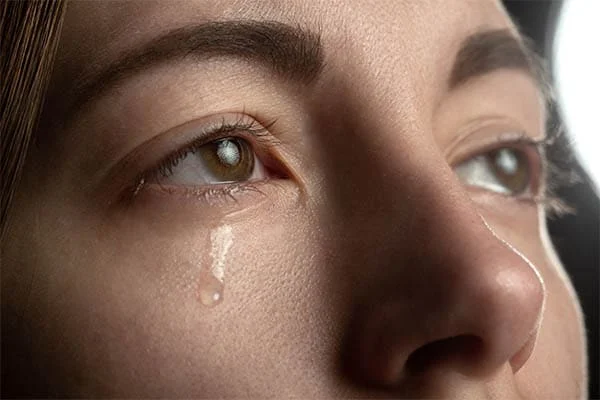 woman with tear rolling down her eye
